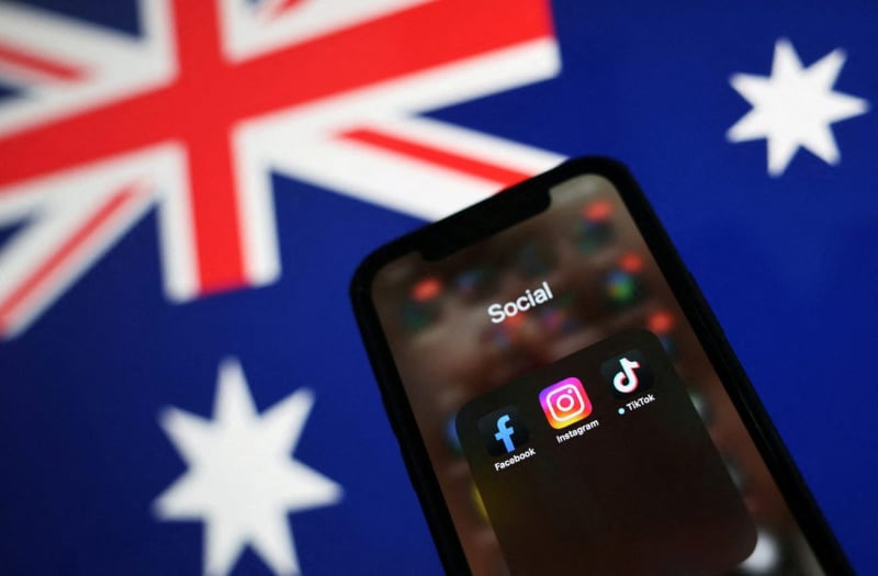 Social media on smartphone in front of an Aussie flag.
