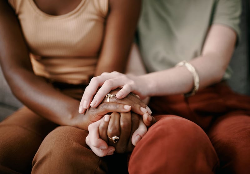 Two people holding hands. Featured image for article