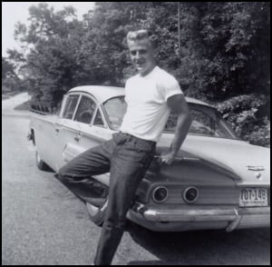 Teenager leans on car in the 1950s